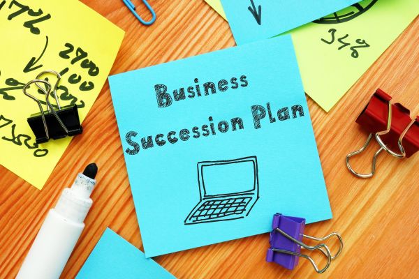 sticky note with business succession plan written on it