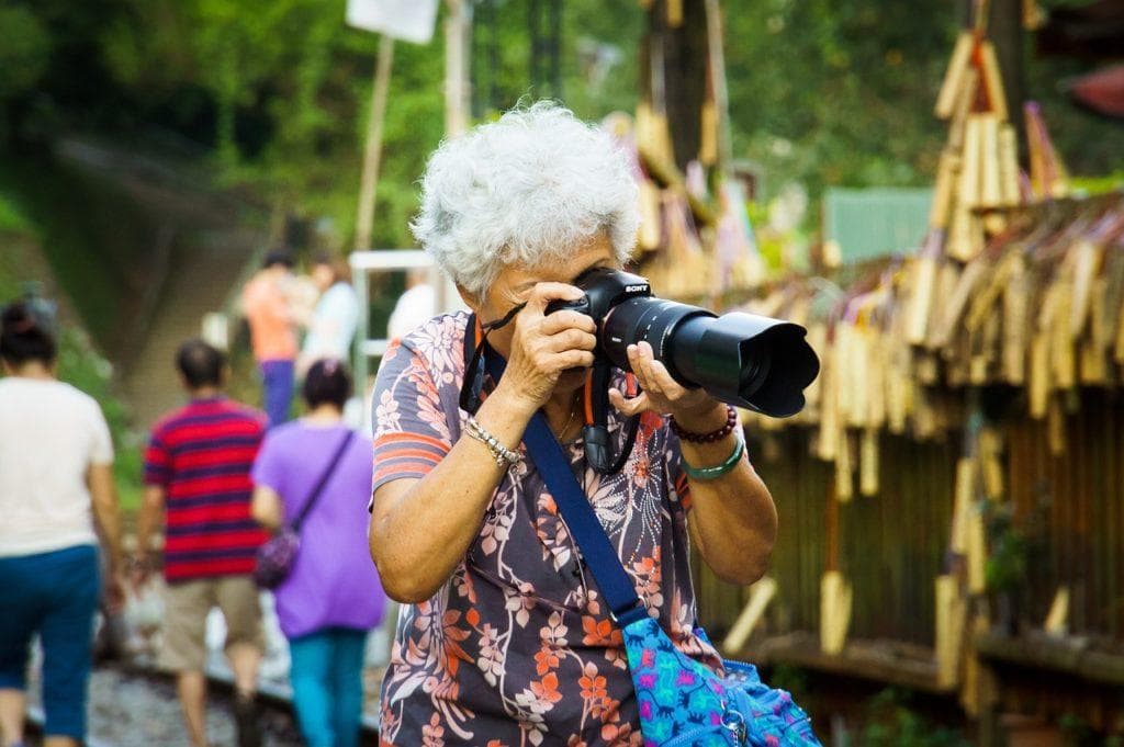 elderly woman taking a photograph