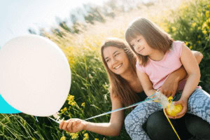 A woman with special needs trusts child holding a balloon